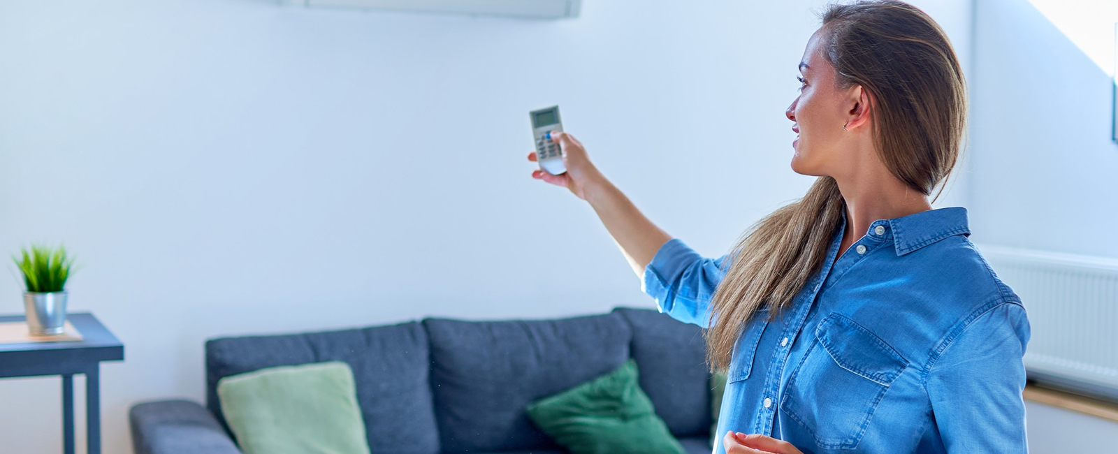 Young Cute Casual Woman Using Air Conditioner Adjusting Comfortable Temperature With Remote Control Apartment